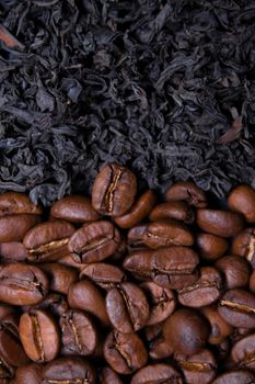 pile stack of dried tea leaves and roasted coffee beans seeds: theine vs caffeine. background .