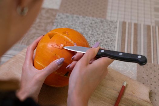 the process of making a Halloween pumpkin. cutting out the mouth. horror theme and Hallowe'en.