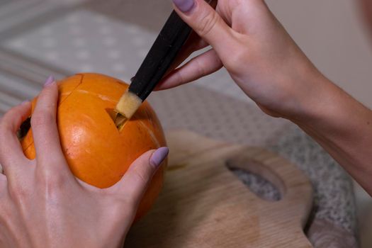 the process of making a Halloween pumpkin. cutting out eyes. horror theme and Hallowe'en.