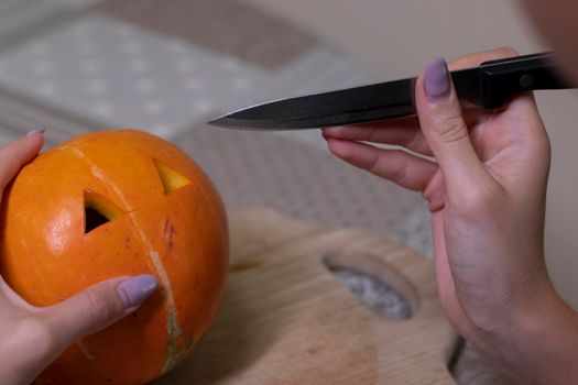 the process of making a Halloween pumpkin. cutting out eyes. horror theme and Hallowe'en.