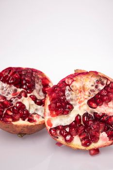 ripe fresh sliced pomegranate fruit with red seeds isolated on white background