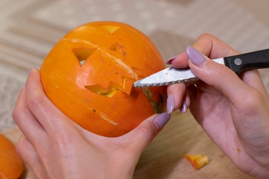 the process of making a Halloween pumpkin. cutting out the mouth. horror theme and Hallowe'en.