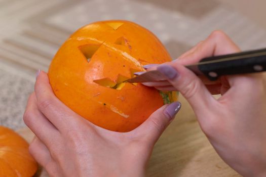 the process of making a Halloween pumpkin. cutting out the mouth. horror theme and Hallowe'en.