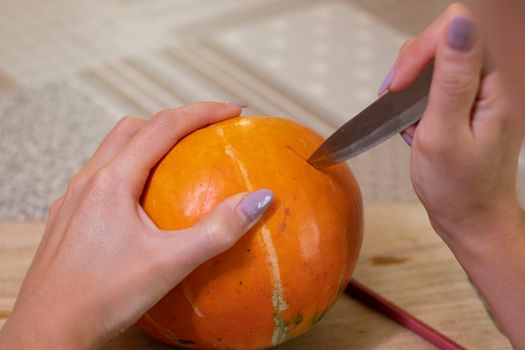 the process of making a Halloween pumpkin. cutting out eyes. horror theme and Hallowe'en.