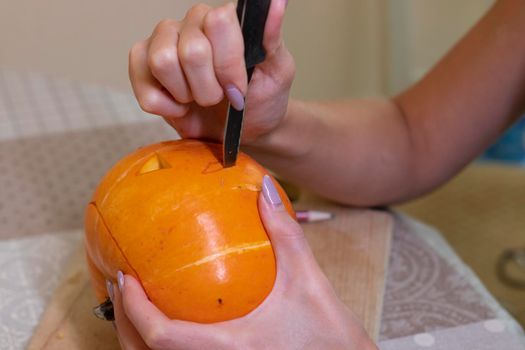 the process of making a Halloween pumpkin. cutting out the mouth. horror theme and Hallowe'en.