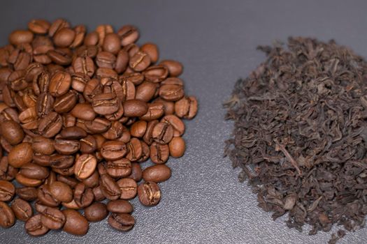 pile stack of dried tea leaves and roasted coffee beans seeds: theine vs caffeine. background .