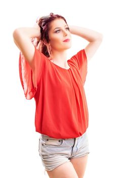 Beautiful redhead woman with long wavy hair in a fashionable summer outfit looking in the distance, isolated on white background. Summer, enjoying concept.