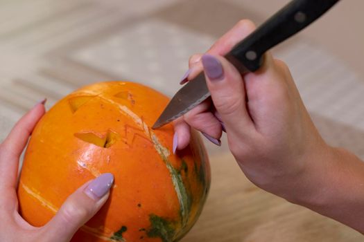 the process of making a Halloween pumpkin. cutting out the mouth. horror theme and Hallowe'en.