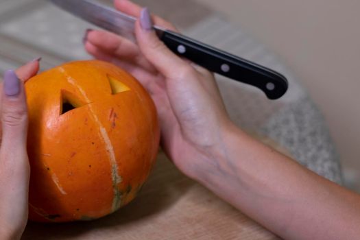 the process of making a Halloween pumpkin. cutting out eyes. horror theme and Hallowe'en.