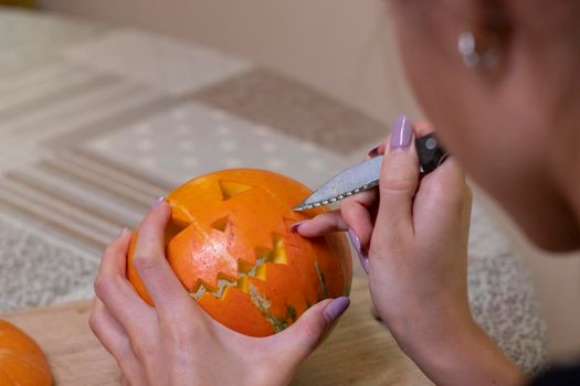 the process of making a Halloween pumpkin. cutting out the mouth. horror theme and Hallowe'en.