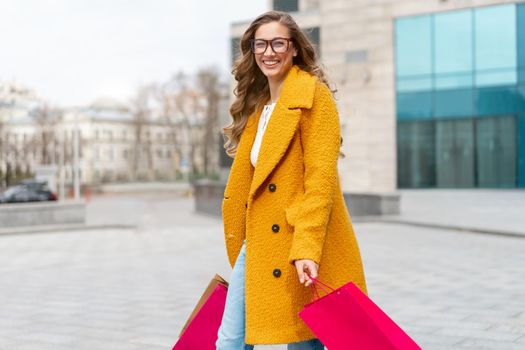 Business Woman With Shopping Bags Dressed Yellow Coat Walking Outdoors Corporative Building Background Caucasian Female Business Person Near Office Building Stylish Businesswoman Season Sale