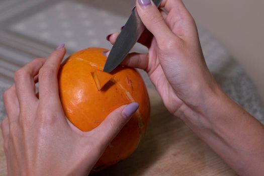 the process of making a Halloween pumpkin. cutting out eyes. horror theme and Hallowe'en.