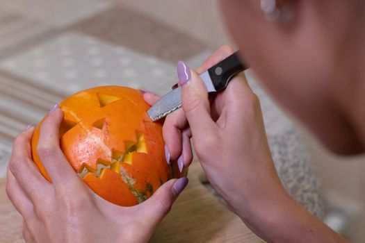 the process of making a Halloween pumpkin. cutting out the mouth. horror theme and Hallowe'en.