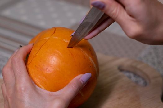 the process of making a Halloween pumpkin. cutting out eyes. horror theme and Hallowe'en.