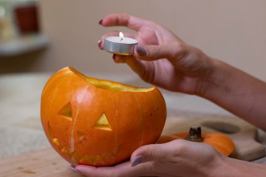 the process of making a Halloween pumpkin. lighted candle. horror theme and Hallowe'en.