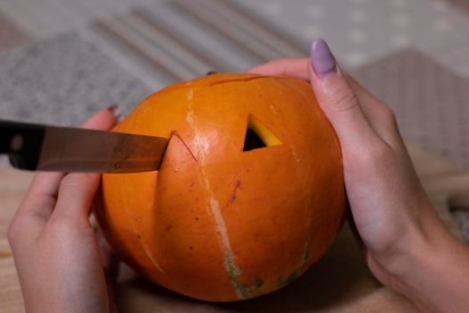 the process of making a Halloween pumpkin. cutting out eyes. horror theme and Hallowe'en.