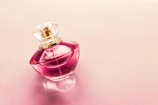 Perfumery, spa and branding concept - Pink perfume bottle on glossy background, sweet floral scent, glamour fragrance and eau de parfum as holiday gift and luxury beauty cosmetics brand design