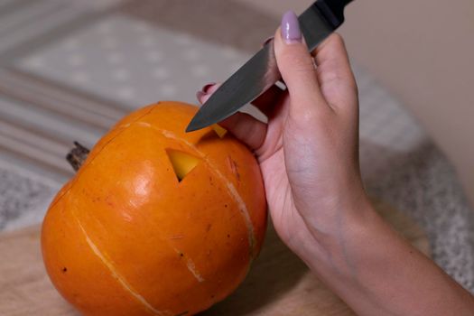 the process of making a Halloween pumpkin. cutting out eyes. horror theme and Hallowe'en.