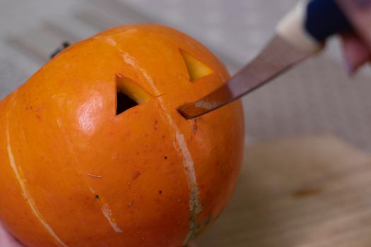 the process of making a Halloween pumpkin. cutting nose. horror theme and Hallowe'en.