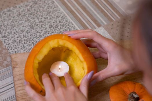 the process of making a Halloween pumpkin. lighted candle. horror theme and Hallowe'en.