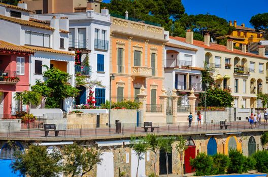 Colorful colonial houses with brightly painted wooden doors on level below street facing beach and ocean.