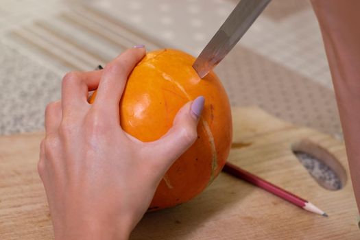 the process of making a Halloween pumpkin. cutting out eyes. horror theme and Hallowe'en.