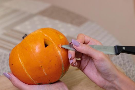 the process of making a Halloween pumpkin. cutting nose. horror theme and Hallowe'en.