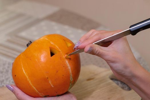 the process of making a Halloween pumpkin. cutting nose. horror theme and Hallowe'en.