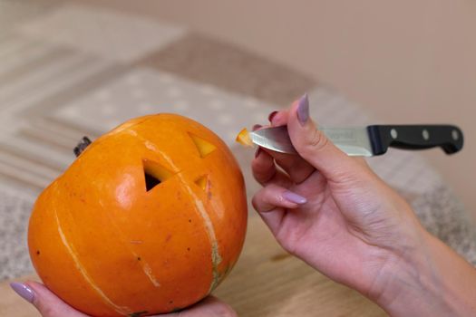 the process of making a Halloween pumpkin. cutting nose. horror theme and Hallowe'en.