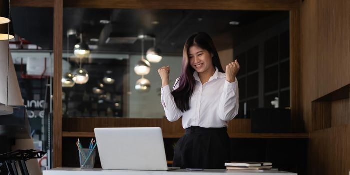 Joyful of Business female in conference together in an office and excited the success on laptop computer screen