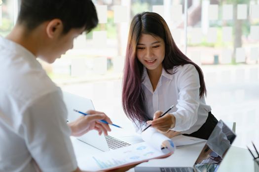 Young asian business and partner colleagues discussing work issues in the workplace