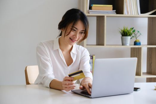 Woman enjoy with online shopping application and looking at laptop for fill credit card number to payment