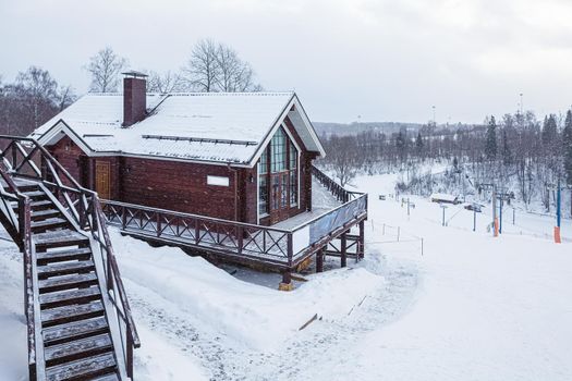 Snowy wooden house on ski resort in Russia