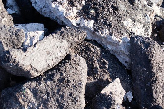 close-up of Old cracked asphalt pavement. concept of reduce reuse recycle. pile of smashed concrete. Destroyed highway, damage and collapse. Disaster results, earthquake or accident.