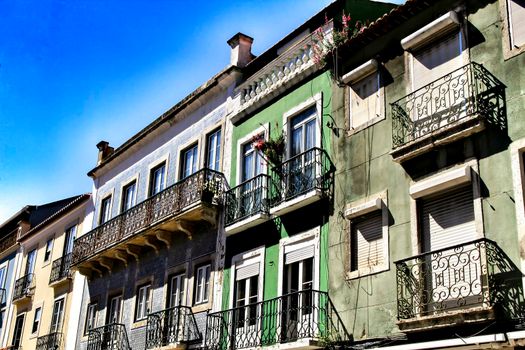 Old colorful and beautiful facades with vintage streetlight in Lisbon streets in Spring. Clothesline in the facade with hanging clothes