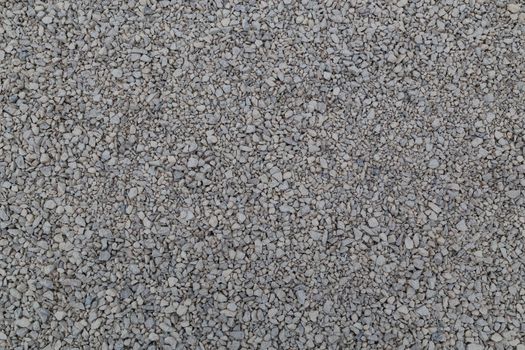 Dry white limestone ballast flat full frame background. Small gray dusty broken macadam stones texture. Viiew from above.