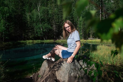 Woman resting at mountain lake in summer, Altai mountains