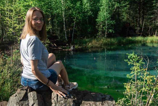 Woman resting at mountain lake in summer, Altai mountains