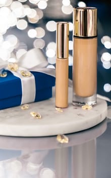 Cosmetic branding, Christmas glitter and girly blog concept - Holiday make-up foundation base, concealer and blue gift box, luxury cosmetics present and blank label products for beauty brand design