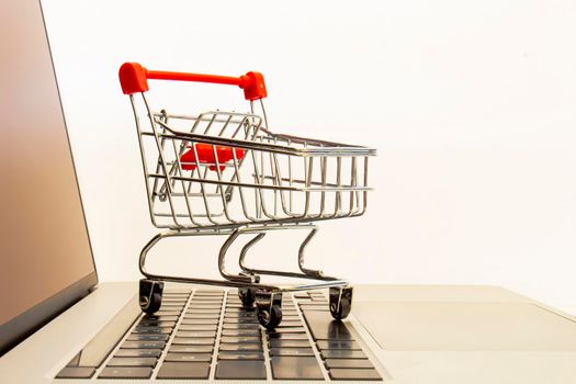 A Supermarket Hand Trolley, Mini Shopping Cart on top of a computer keyboard. Concept: Online shopping.
