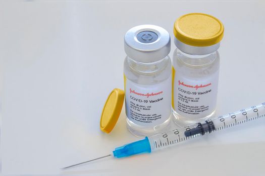 Calgary, Alberta, Canada. April 29, 2021. A couple of Johnson & Johnson dosis of Covid-19 vaccines on vial bottles and an injection syringe.