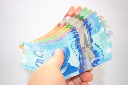 Calgary, Alberta. Canada. April 02, 2021. A person holding canadian bank notes bills.