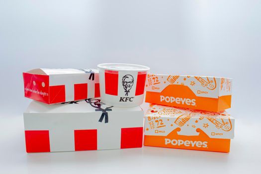 Calgary, Alberta, Canada. May 5, 2021. KFC and Popeyes Fast food boxes on a clear background.