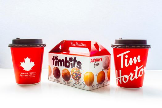 Calgary, Alberta Canada. May 7, 2021. A couple of Tim Hortons coffee cups with a timbits box.
