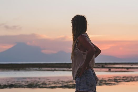 Young blonde girl on Gili Trawangan beach in Lombik, Indonesia at sunset time.