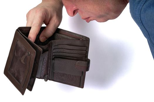 Man looking into open empty wallet, poverty and bankruptcy concept. Close up