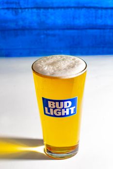Calgary AB, Canada. October 1, 2019. Bud Light Pint Beer on a white table with a wooden wall.