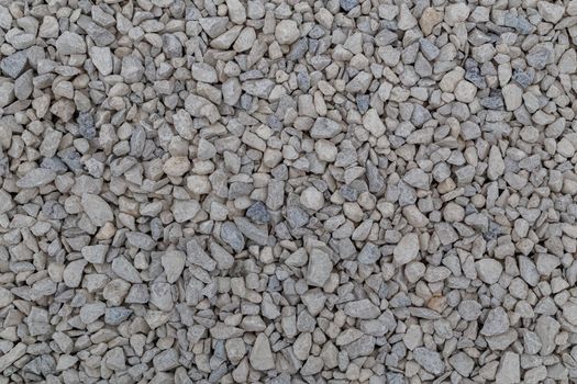 Dry white limestone ballast flat full frame background. Small gray dusty broken macadam stones texture. Viiew from above.