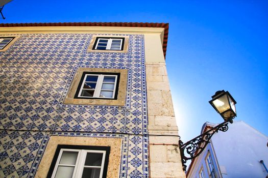Old colorful and beautiful facades with vintage streetlight in Lisbon streets in Spring. Clothesline in the facade with hanging clothes