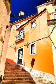 Old colorful and beautiful facades with vintage streetlight in Lisbon streets in Spring. Clothesline in the facade with hanging clothes